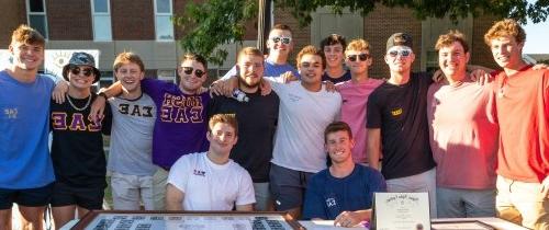 Centre fraternity brothers smiling at the activities expo